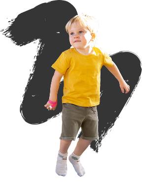 Young child with blonde hair, wearing a yellow shirt and brown shorts, jumping against a black background. They appear joyful and energetic.