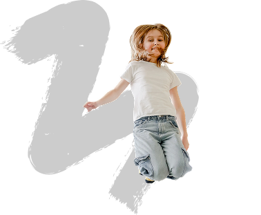 A child with long hair jumps joyfully against a black background. They wear a white t-shirt and jeans, capturing a moment of carefree happiness.